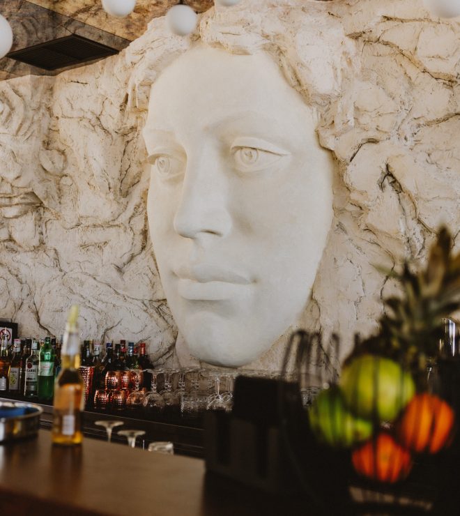 Close-up of sculpted face wall above the bar at GAL Split