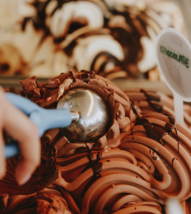 Close-up of chocolate gelato with drizzle being scooped