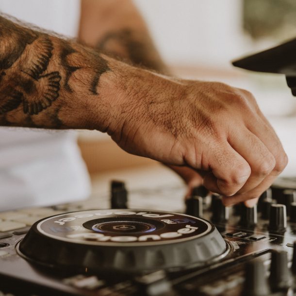 Close-up of DJ hand adjusting mixer knobs at GAL Split