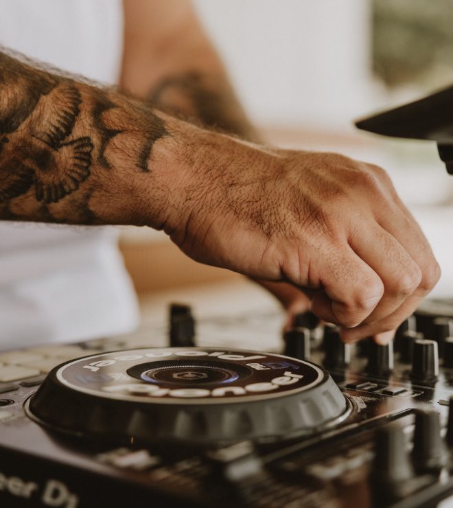 Close-up of DJ hand adjusting mixer knobs at GAL Split
