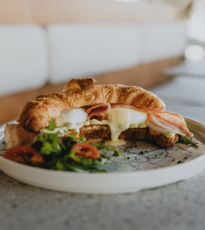 Fresh croissant sandwich with ham, melted cheese, and arugula salad at GAL Split